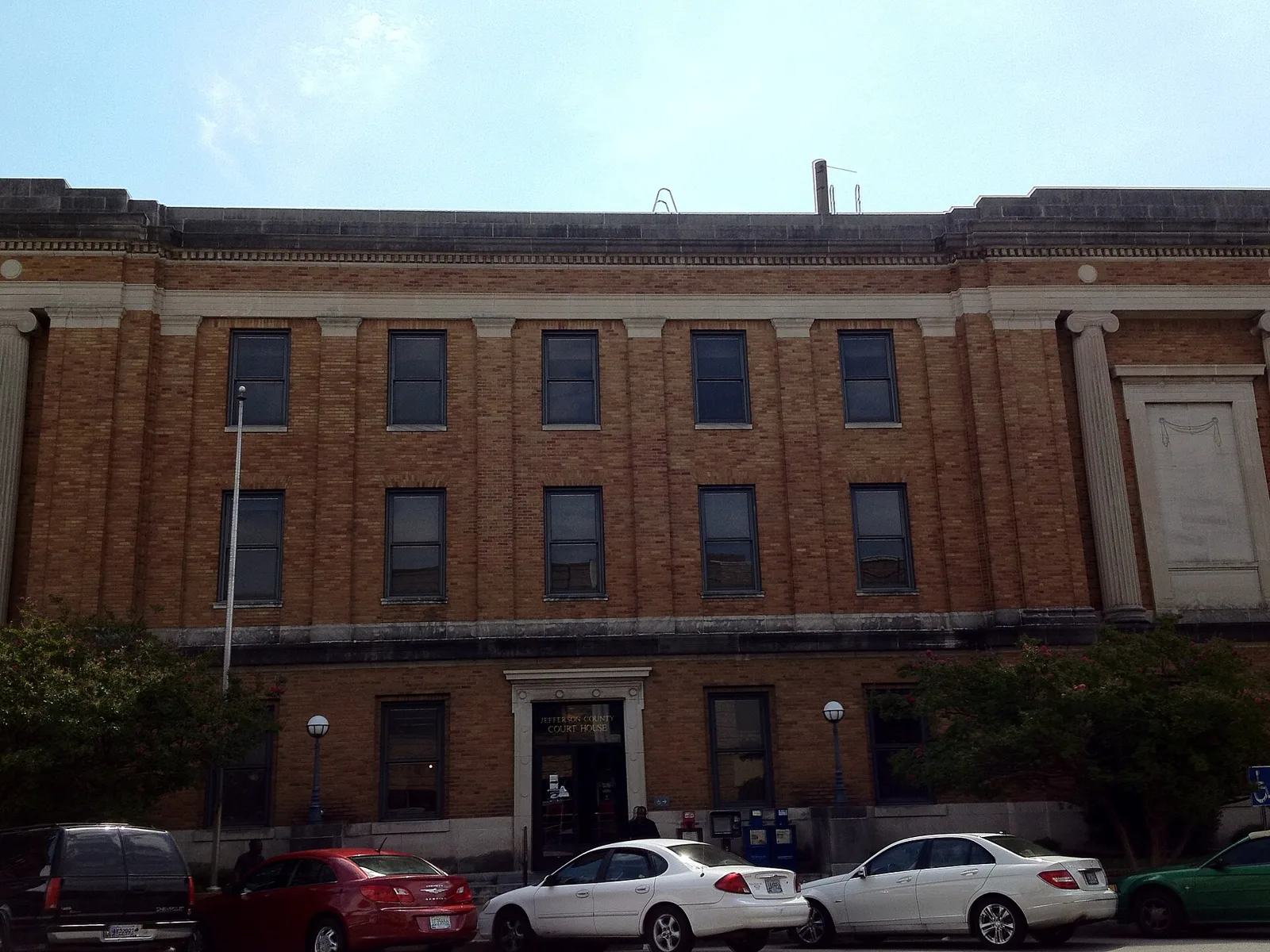 The entrance to the Jefferson County Courthouse in Bessemer, with newspaper boxes beside the door.